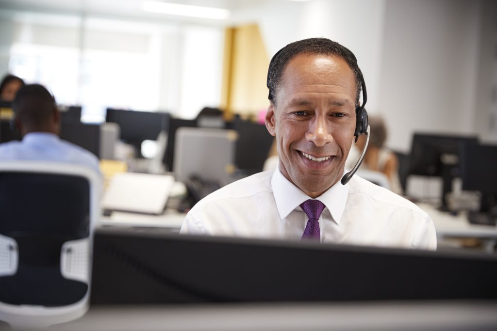 A middle-aged customer service representative wearing a headset.